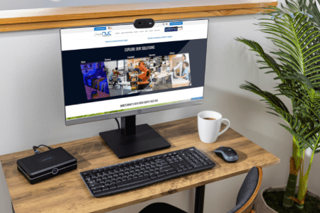 Mini PC Gaming diletakkan di atas meja di sebelah monitor — setup SFF yang rapi