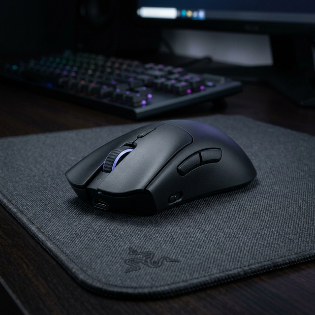 Mouse gaming wireless premium di atas mousepad lebar dengan kabel charging tersampir rapi